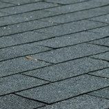 A close up of the asphalt shingles on the roof.