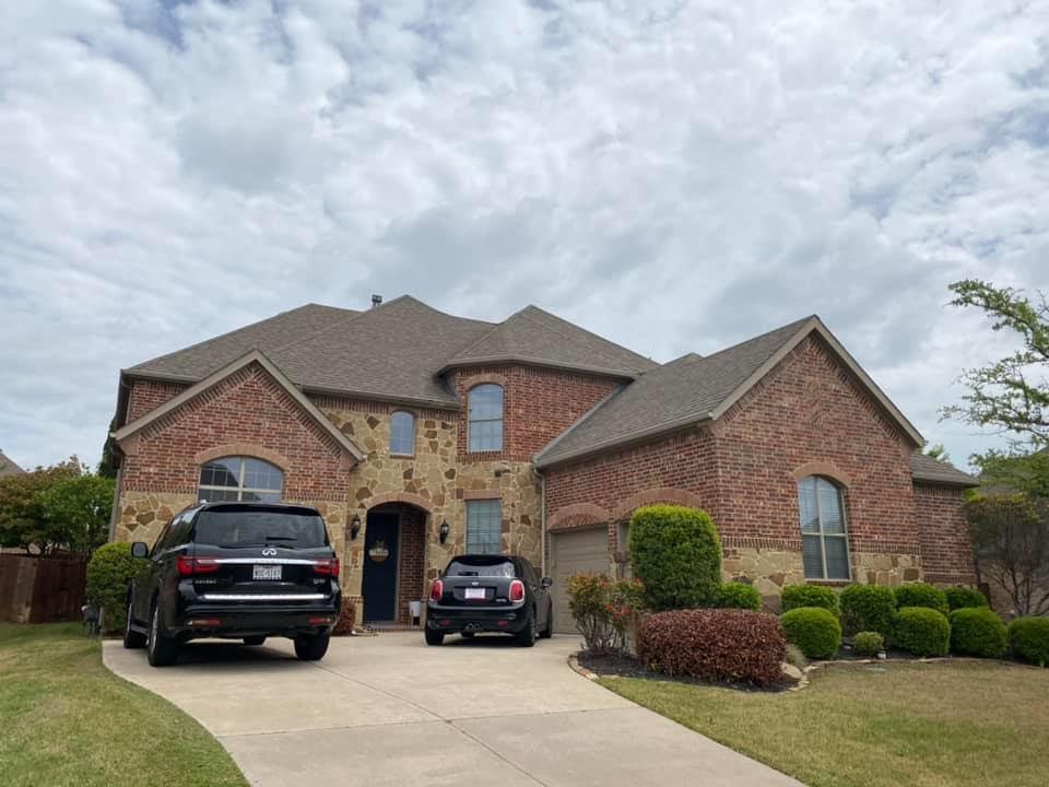 A house with two cars parked in front of it.