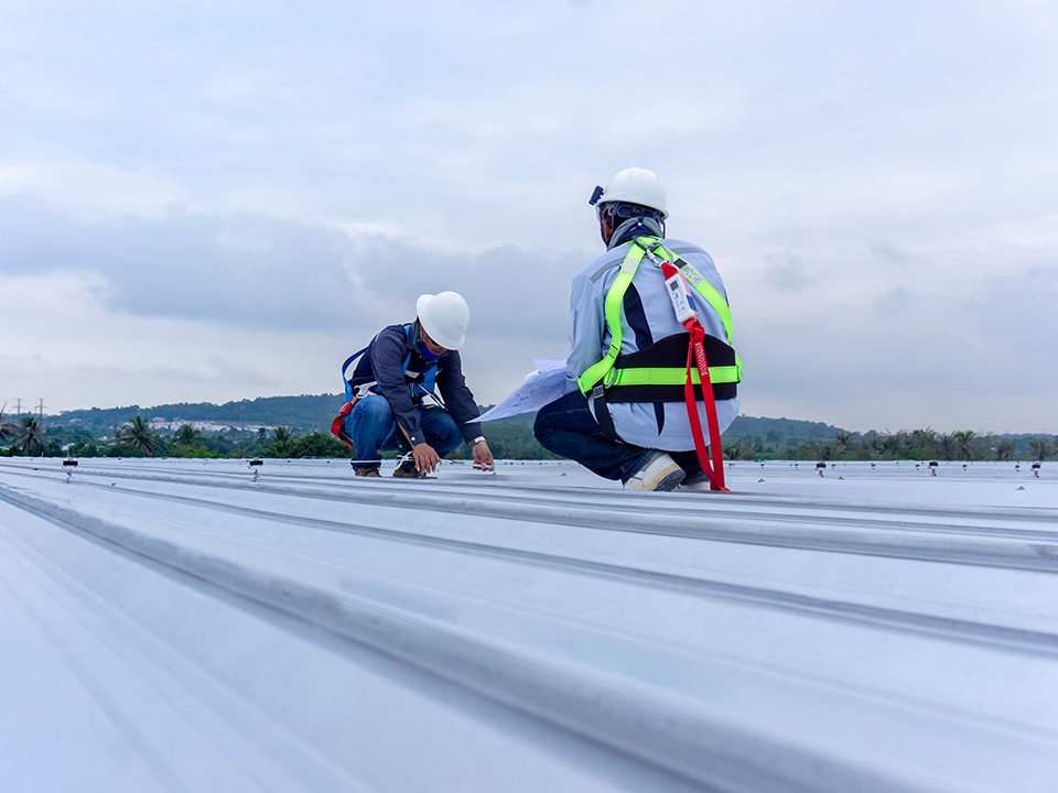 Two men are working on a roof.